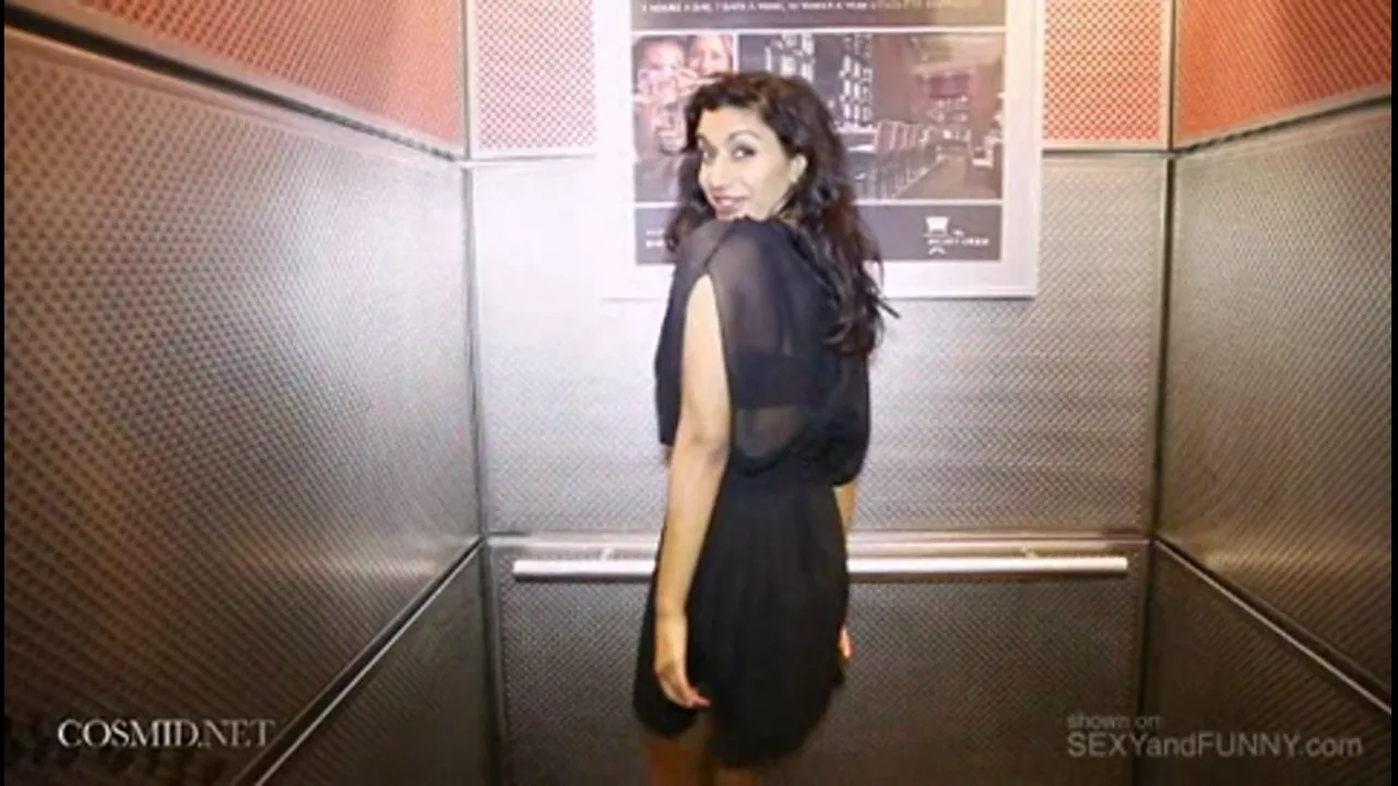 Busty Brunette Strips in a Hotel Hallway